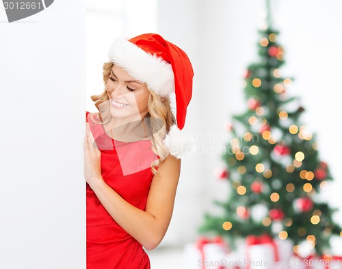 Image of smiling young woman in santa hat with white board