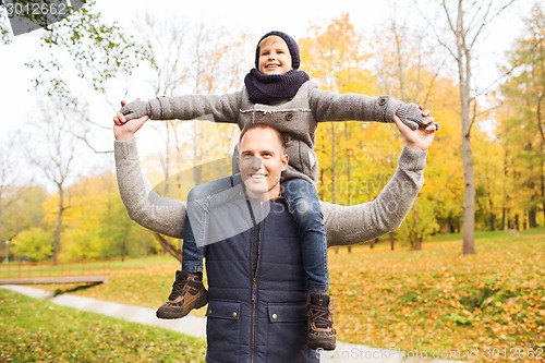 Image of happy family having fun in autumn park