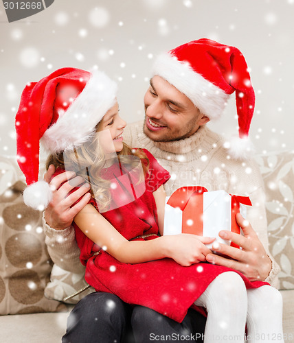 Image of smiling father and daughter holding gift box