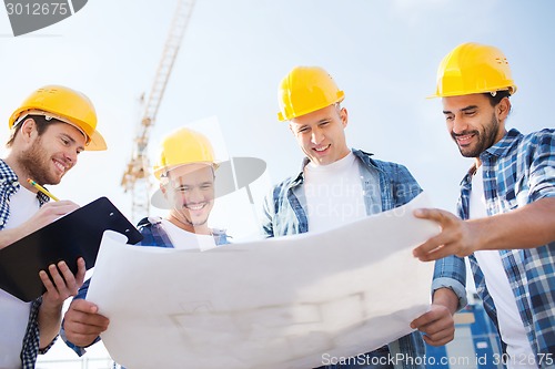 Image of group of builders with tablet pc and blueprint