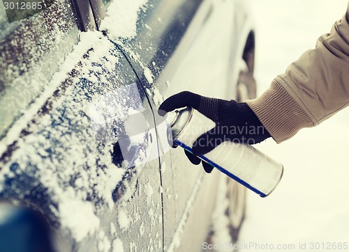 Image of closeup of man hand with lock door de-icer