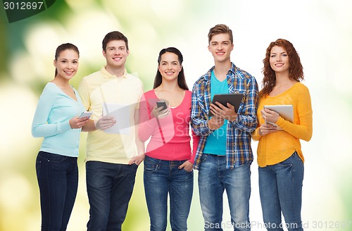 Image of group of teenagers with smartphones and tablet pc