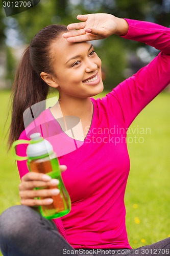 Image of smiling teenage girl showing bottle