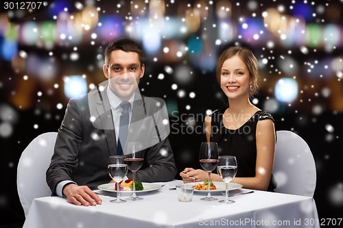 Image of smiling couple eating main course at restaurant