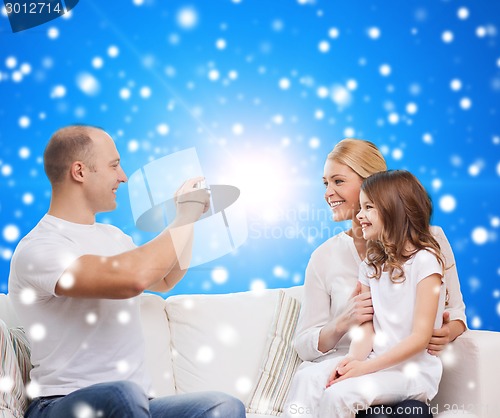 Image of happy family with camera at home