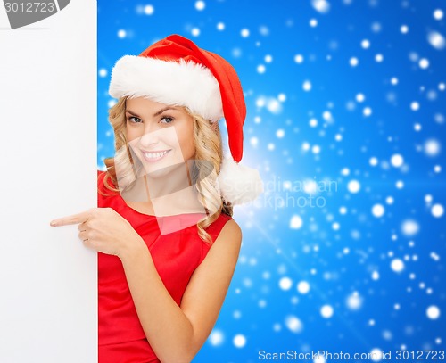 Image of smiling young woman in santa hat with white board