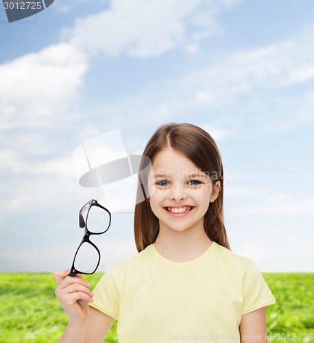 Image of smiling cute little girl holding black eyeglasses