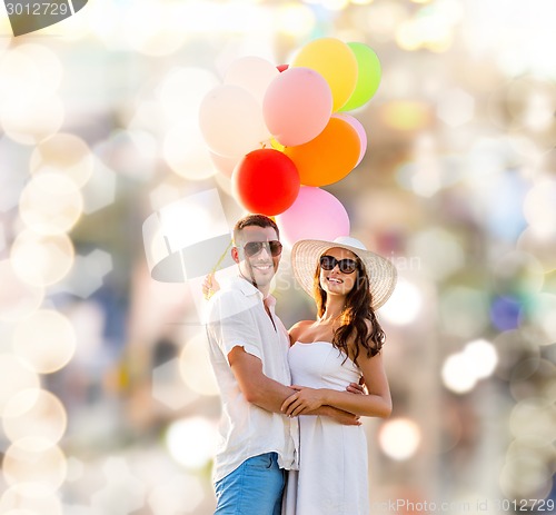 Image of smiling couple with air balloons outdoors