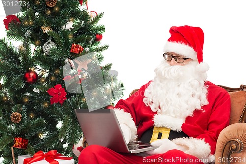 Image of man in costume of santa claus with laptop