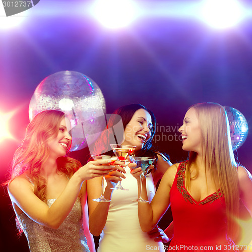 Image of three smiling women with cocktails and disco ball