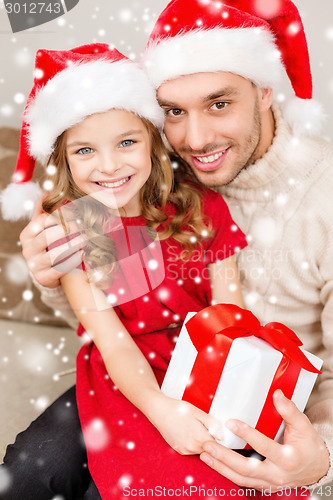 Image of smiling father and daughter holding gift box
