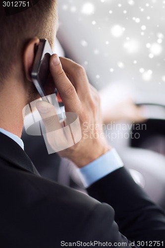 Image of close up of man using smartphone while driving car