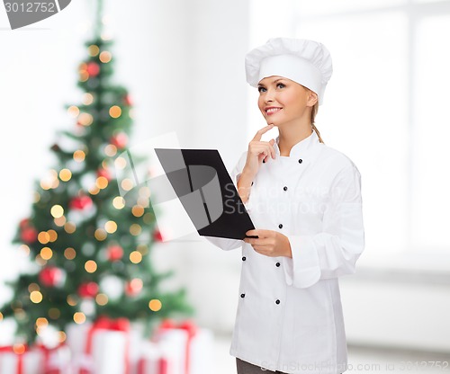 Image of smiling female chef with black blank paper