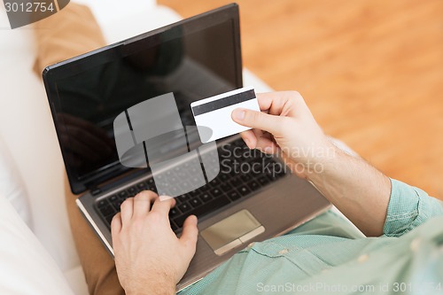 Image of close up of man with laptop and credit card