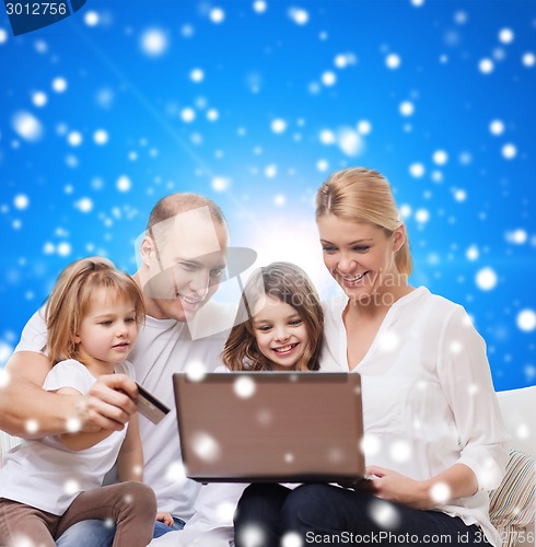 Image of happy family with laptop computer and credit card