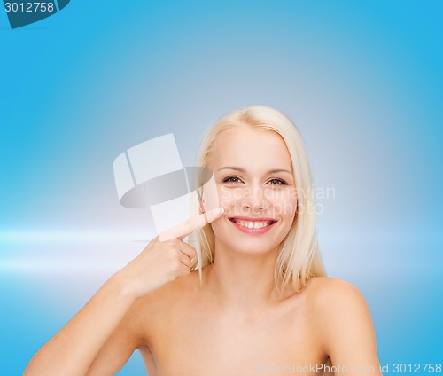 Image of smiling young woman pointing to her nose