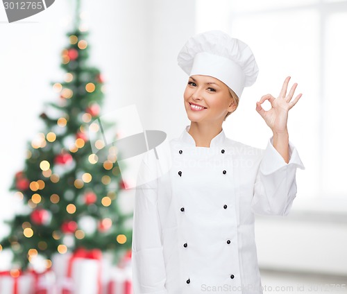 Image of smiling female chef showing ok gesture