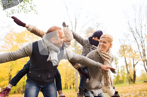 Image of happy family having fun in autumn park