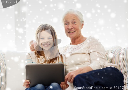 Image of smiling family with tablet pc at home