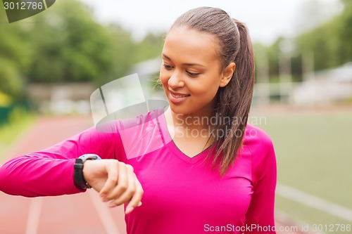 Image of smiling woman running on track outdoors