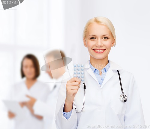 Image of smiling female doctor with pills