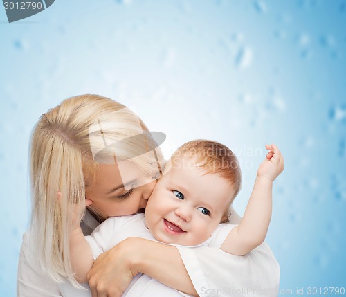 Image of happy mother kissing smiling baby