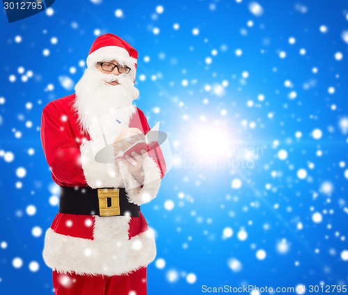 Image of man in costume of santa claus with notepad