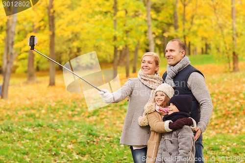 Image of happy family with smartphone and monopod in park