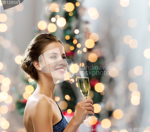 Image of smiling woman holding glass of sparkling wine