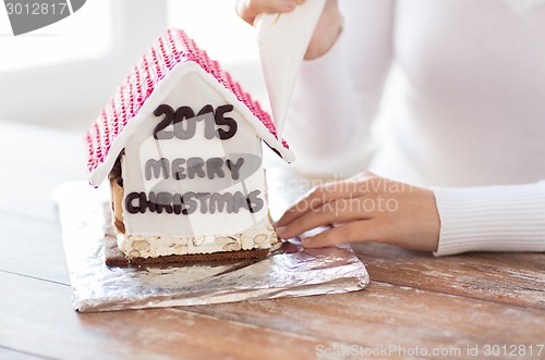 Image of close up of woman making gingerbread houses