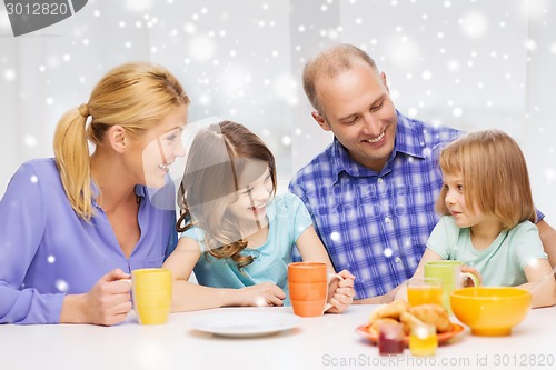 Image of happy family with two kids having breakfast