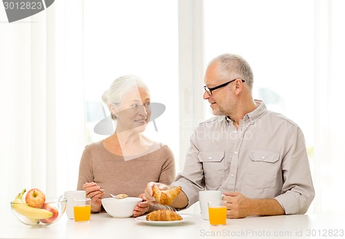 Image of happy senior couple having breakfast at home