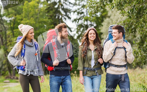 Image of group of smiling friends with backpacks hiking