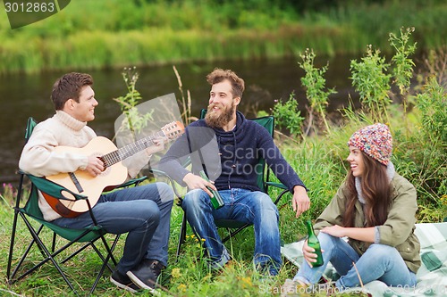 Image of group of tourists playing guitar in camping