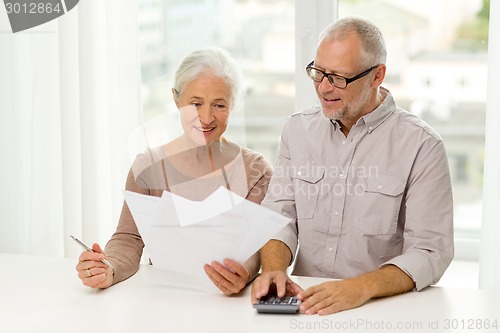 Image of senior couple with papers and calculator at home