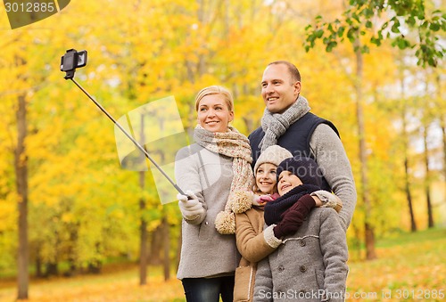 Image of happy family with smartphone and monopod in park