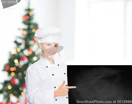 Image of smiling female chef with white blank board