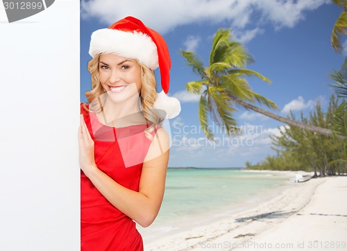 Image of smiling young woman in santa hat with white board