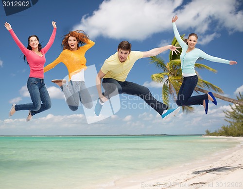 Image of group of smiling teenagers jumping in air