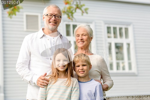 Image of happy family in front of house outdoors