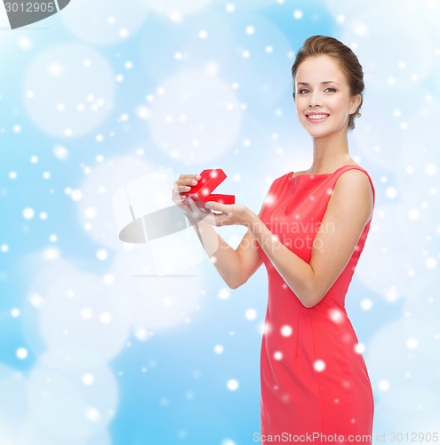 Image of smiling young woman in red dress with gift box