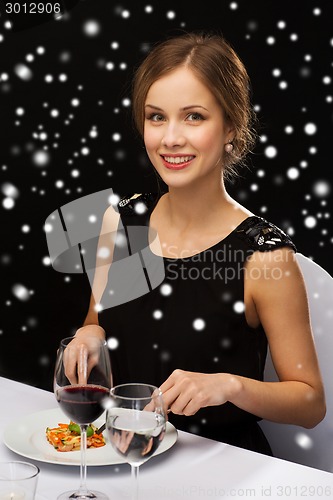 Image of smiling woman with tablet pc eating main course