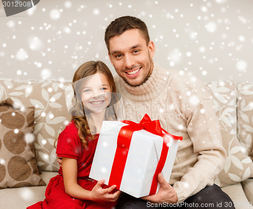 Image of smiling father and daughter holding gift box