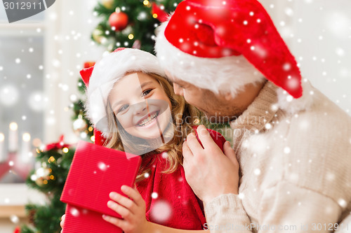 Image of smiling father and daughter holding gift box