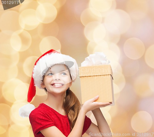 Image of smiling girl in santa helper hat with gift box