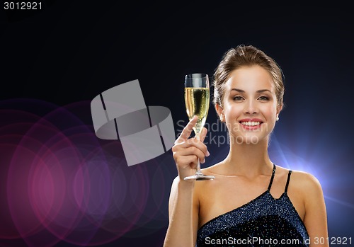 Image of smiling woman holding glass of sparkling wine