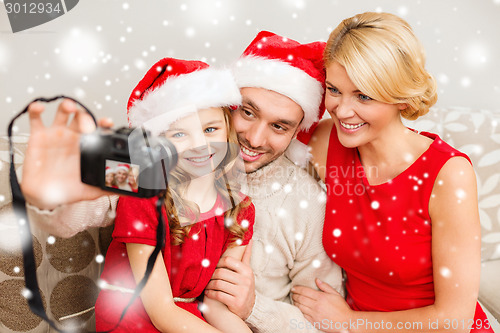 Image of happy family with digital camera taking photo