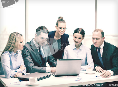 Image of business team with laptop having discussion