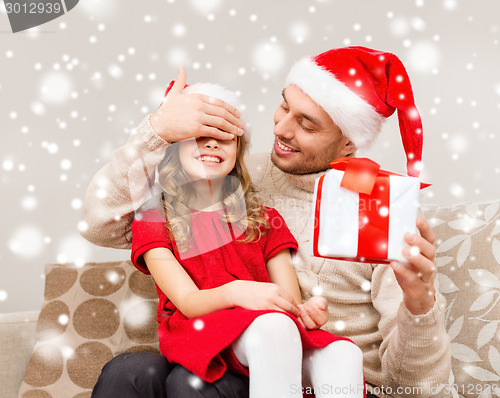 Image of smiling father and daughter holding gift box