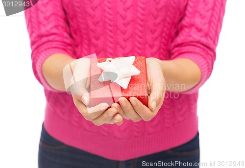 Image of close up of woman in pink sweater holding gift box